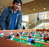 Photo of a man playing foosball. Links to Tangible Personal Property.